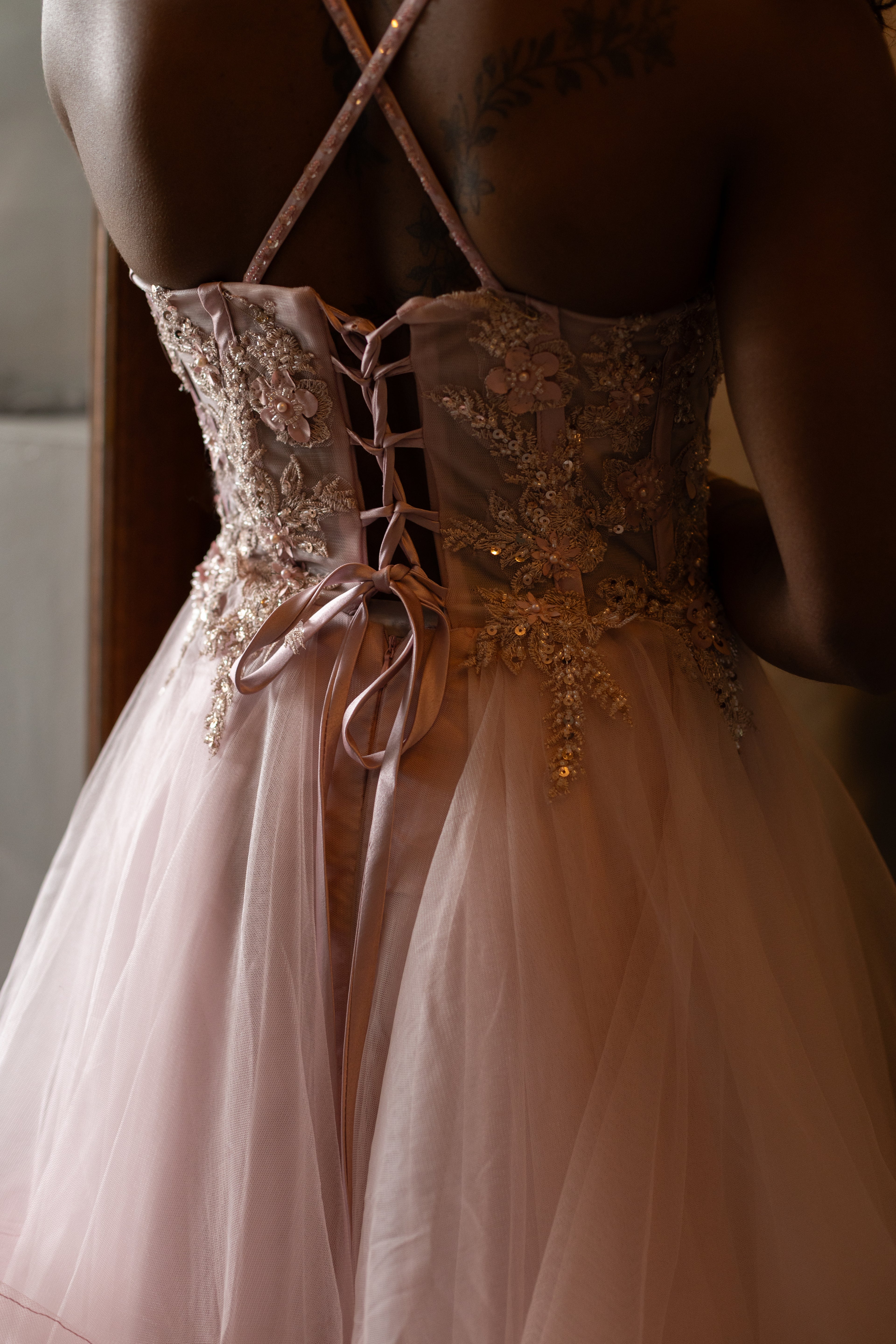 Soft pink layered dress with floral beaded top and lace up back.